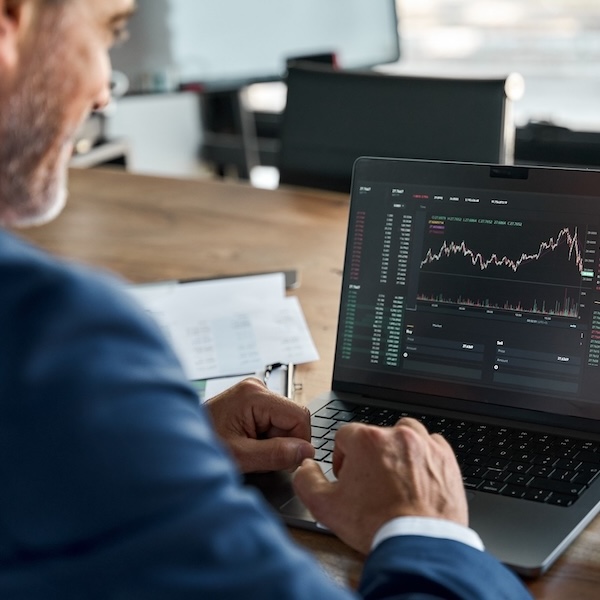 man trading stocks on laptop
